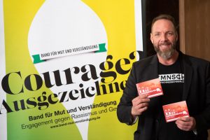 Der Berliner Fotograf Alexander Mechow mit seinem Piktogrammbuch für Migranten und ankommende Flüchtlinge.